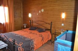 1 dormitorio con 1 cama en una habitación con paredes de madera en Casas de Montanha da Gralheira, en Gralheira