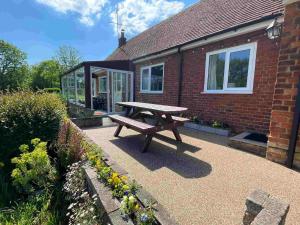 a picnic table sitting outside of a brick house at Waterside Cottage - Sleeps 11 on Grand Union Canal in Linslade
