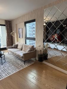 a living room with a couch and a large window at Belgrade Waterfront Sky & River View Residences in Belgrade