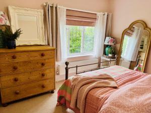 a bedroom with a bed and a dresser and a window at 5 - Spacious Countryside House for Families & Groups in Pont Sticill