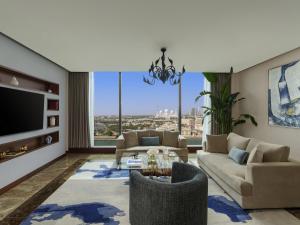 a living room with two couches and a tv at Fairmont Bab Al Bahr in Abu Dhabi