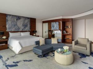 a bedroom with a bed and a couch and a chair at Fairmont Bab Al Bahr in Abu Dhabi