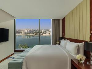a bedroom with a large white bed and a large window at Fairmont Bab Al Bahr in Abu Dhabi +264 photos
