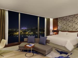 a bedroom with a large bed and a large window at Fairmont Bab Al Bahr in Abu Dhabi