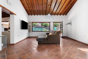 a living room with a couch and a tv at Villa Alma in Vega de San Mateo