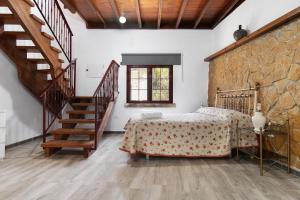 a bedroom with a bed and a stone wall at Villa Alma in Vega de San Mateo