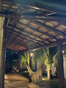 a hammock under a pergola with two palm trees at Bangalô raizes in São Gonçalo do Amarante