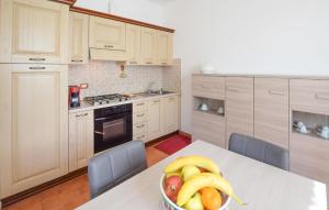 Una cocina con una mesa con un bol de fruta encima. en 2 Bedroom Nice Home In Porchiano, en Porchiano