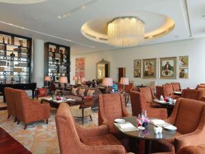 a restaurant with tables and chairs and a chandelier at Raffles Makati in Manila