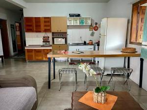 a kitchen with a table and chairs and a refrigerator at Casa de campo Maria&Maria próximo a cidade de Juiz de Fora MG in Juiz de Fora