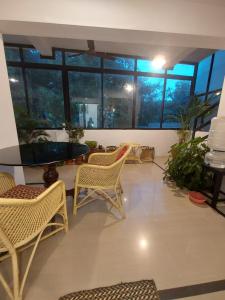 a room with chairs and a table and windows at Taj Mahal Hotel in Cochin