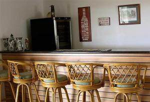 a bar with four chairs in front of a counter at Taits Place Vineyard B & B in Thulimbah