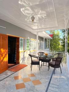 a patio with a table and chairs on a porch at Shangrilla House Murree, Bhurban in Murree