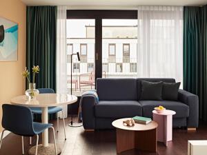 a living room with a couch and a table at Numa Stuttgart Rotebühlplatz in Stuttgart +34 photos