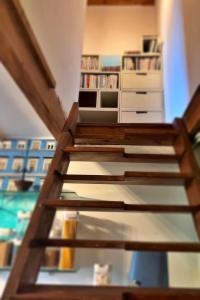 a staircase leading up to a room with a book shelf at Chez Benoit, séjour Zen, chambre d'amis in Mazerolles +12 photos