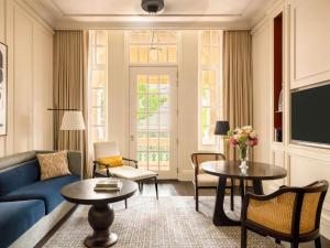 a living room with a blue couch and tables at Raffles Singapore in Singapore