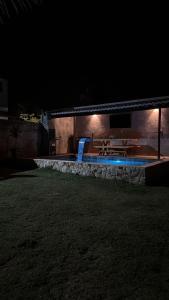 a building with a swimming pool at night at Bangalô raizes in São Gonçalo do Amarante