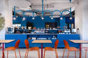 um restaurante com balcões azuis e cadeiras laranja em CX Naples Centrale em Nápoles