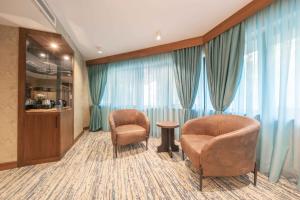 2 sillas y una mesa en una habitación con cortinas en Grand Canyon Hotel, en Ankara