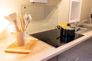 a cup of utensils on a counter next to a stove at Ferienwohnung Tatort in Sankt Andreasberg
