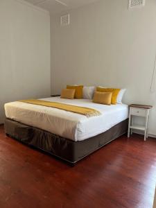 a large bed in a bedroom with a wooden floor at Musgrave Escape in Durban