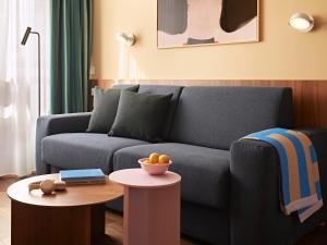 a living room with a couch and a table at Numa Stuttgart Rotebühlplatz in Stuttgart