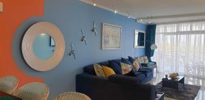 a living room with a couch and a mirror at Seaside Riviera in Cape Town