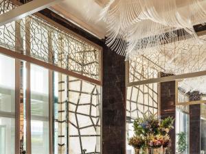 een kamer met ramen met bloemen en een kroonluchter bij Raffles Istanbul in Istanbul