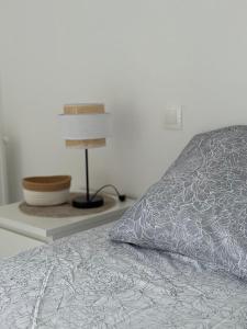 a bed with a pillow and a lamp on a shelf at L'R de Malo studio cosy in Dunkerque