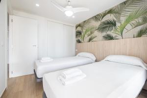 two beds in a room with a mural on the wall at Niza 11-A Apartment Levante Beach in Benidorm