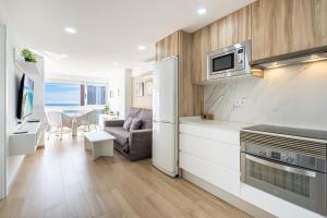 a kitchen and living room with a refrigerator and a couch at Niza 11-A Apartment Levante Beach in Benidorm