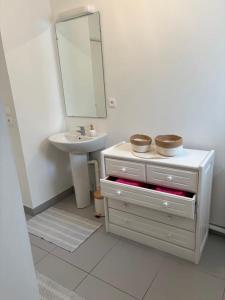 a white bathroom with a sink and a mirror at L'R de Malo studio cosy in Dunkerque