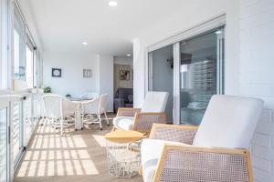 a balcony with chairs and tables on a building at Niza 11-A Apartment Levante Beach in Benidorm +24 photos