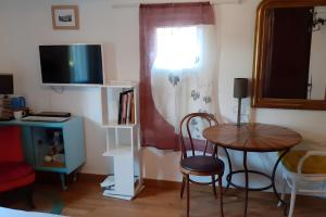 a room with a table and a chair and a desk at Au Jardin Des Couleurs in Pierrefeu-du-Var