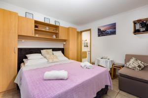 1 dormitorio con 1 cama morada y 2 toallas en Apartment Kreslin, en Vantačići