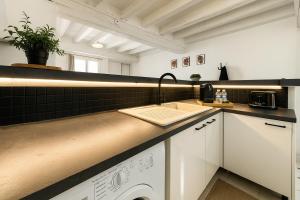 a kitchen with white cabinets and a sink at Grace Even's Loft - Charme Médiéval & Confort Moderne - Wi-Fi Fibre, Netflix & Cuisine Équipée - Séjour Idéal en Duo ou Solo in Donnemarie-en-Montois +7 photos