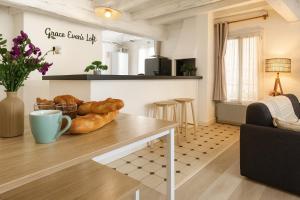 a kitchen and living room with a table with bread on it at Grace Even's Loft - Charme Médiéval & Confort Moderne - Wi-Fi Fibre, Netflix & Cuisine Équipée - Séjour Idéal en Duo ou Solo in Donnemarie-en-Montois
