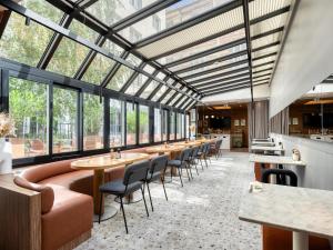 a restaurant with tables and chairs and windows at Mercure Paris 15 Porte de Versailles in Paris