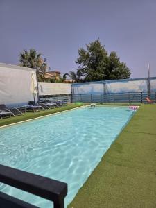 une piscine avec de l'eau bleue dans une cour dans l'établissement villa oltremare resort, à Bagheria
