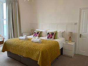 a bedroom with a bed with butterfly pillows on it at Waves End, St Ives, Hot tub and Parking in St Ives +82 photos
