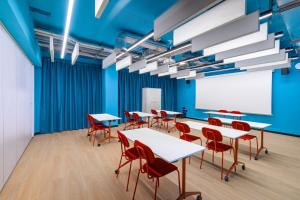uma sala de aula com mesas e cadeiras e um quadro branco em CX Naples Centrale em Nápoles