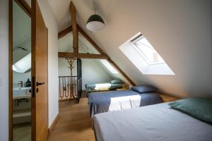 a attic bedroom with two beds and a window at Les GRANDS enfants - 1h15 de Paris - Piscine intérieure chauffée - Offres Pro in Subligny +31 photos