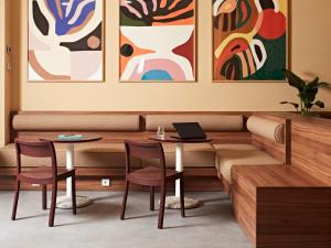 a restaurant with two tables and paintings on the wall at Numa Stuttgart Rotebühlplatz in Stuttgart