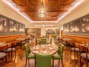 a restaurant with wooden tables and green chairs at Fairmont Mount Kenya Safari Club in Nanyuki