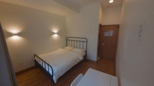a small bedroom with a bed with white sheets at U.S. Pacific Hotel in New York