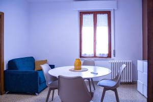 a living room with a table and chairs and a blue couch at La Corte Del Pane in Corridonia