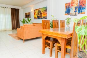 Una sala de estar con una mesa y sillas de madera. en Villa Tuskaara, en Tangalle