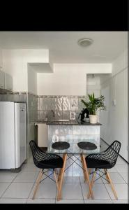 a kitchen with a glass table and two chairs at Luxo in Caruaru