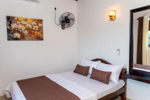 un dormitorio con una cama y un espejo en Villa Tuskaara, en Tangalle