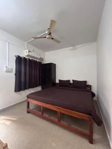a bedroom with a bed and a ceiling fan at Gajalee Beach House in Bhogwe